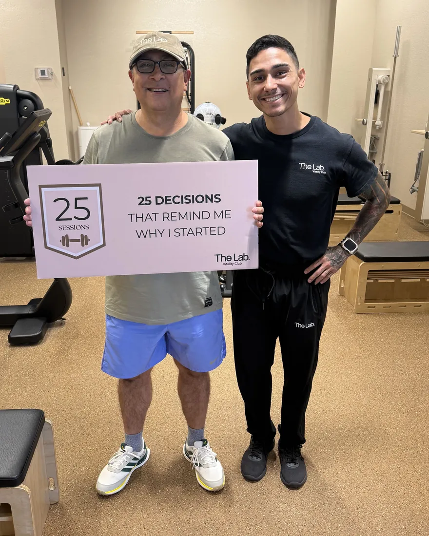 Mario, 61, holding his 25 sessions sign next to his mentor at The Lab in Hallandale Beach